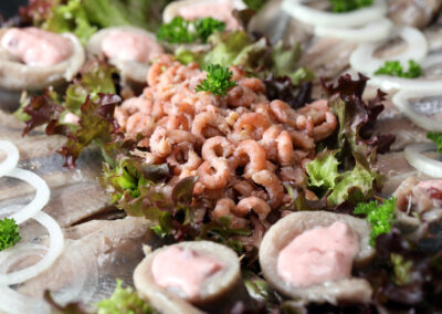 Nordsee-Krabbenfleisch, Matjes-Röllchen mit Preiselbeeren und Zwiebelringen auf der Matjesplatte