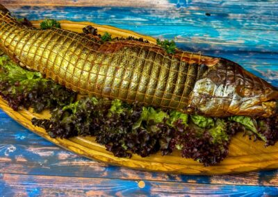 Ganzer Lachs im Netz auf Salatbett, Fischspezialität der Wuppertaler Fischkultur