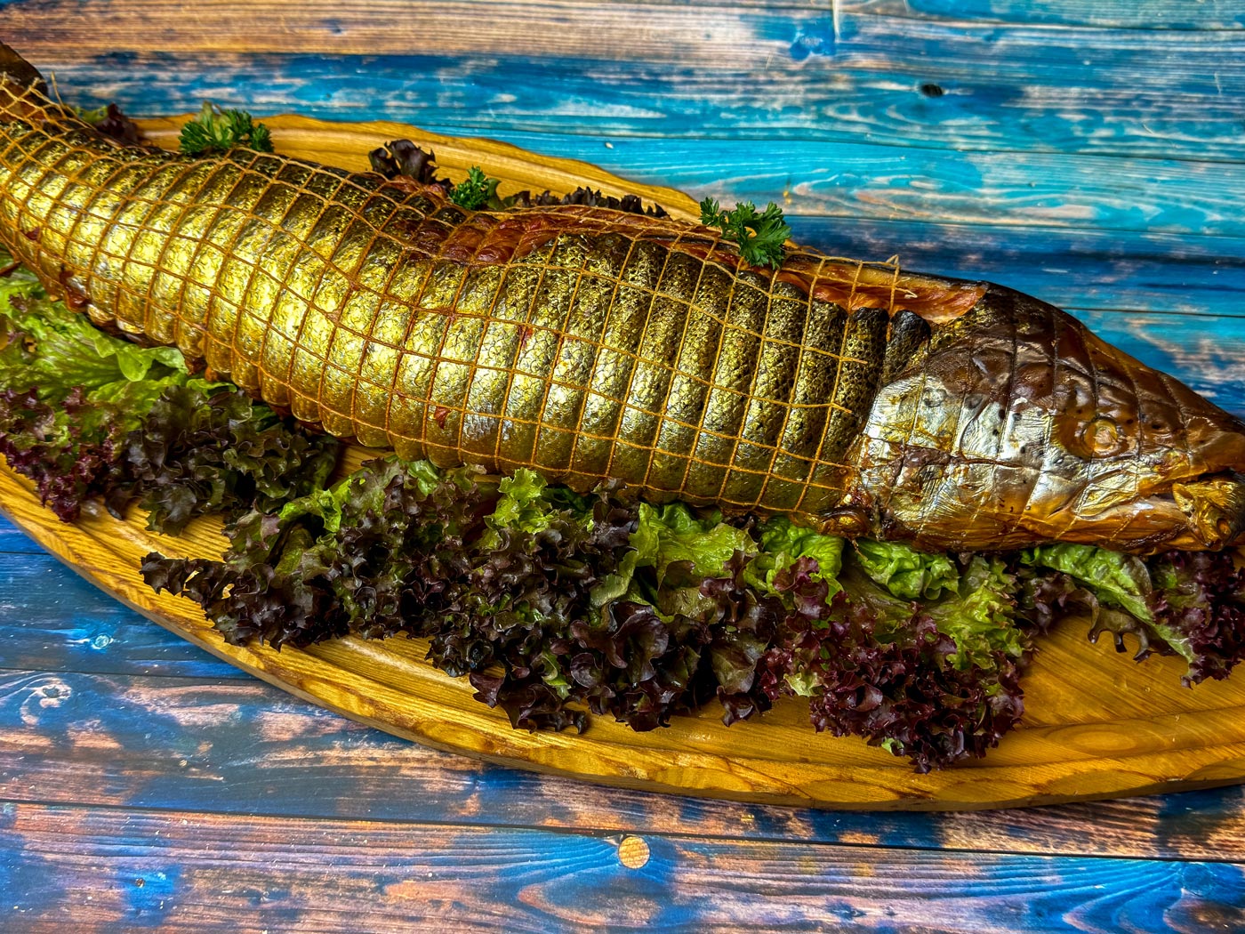 Ganzer Lachs im Netz auf Salatbett, Fischspezialität der Wuppertaler Fischkultur